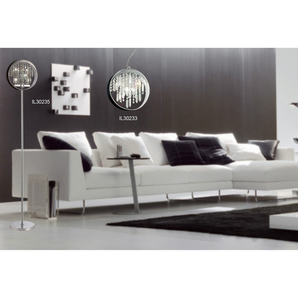 A modern living room with a white sectional, black and white pillows, the Geo 9 Light Crystal Floor Lamp (chrome with black shade), a round crystal-accented chandelier, dark accent wall, and minimalist decor.