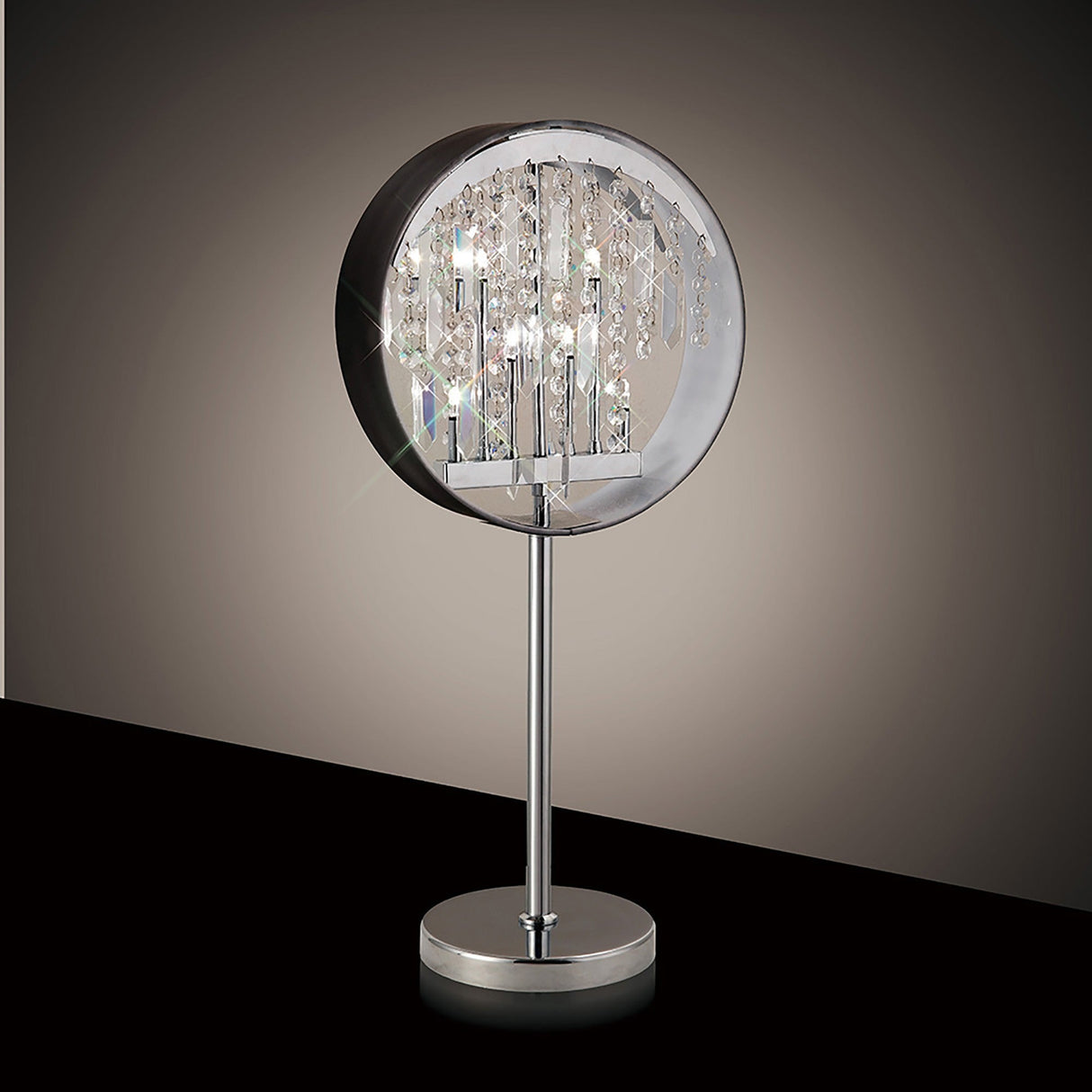 The Geo Crystal 7 Light Table Lamp in polished chrome features a circular chrome shade, hanging crystal accents, and a slim metal stand on a round base, glowing elegantly against a dark background.