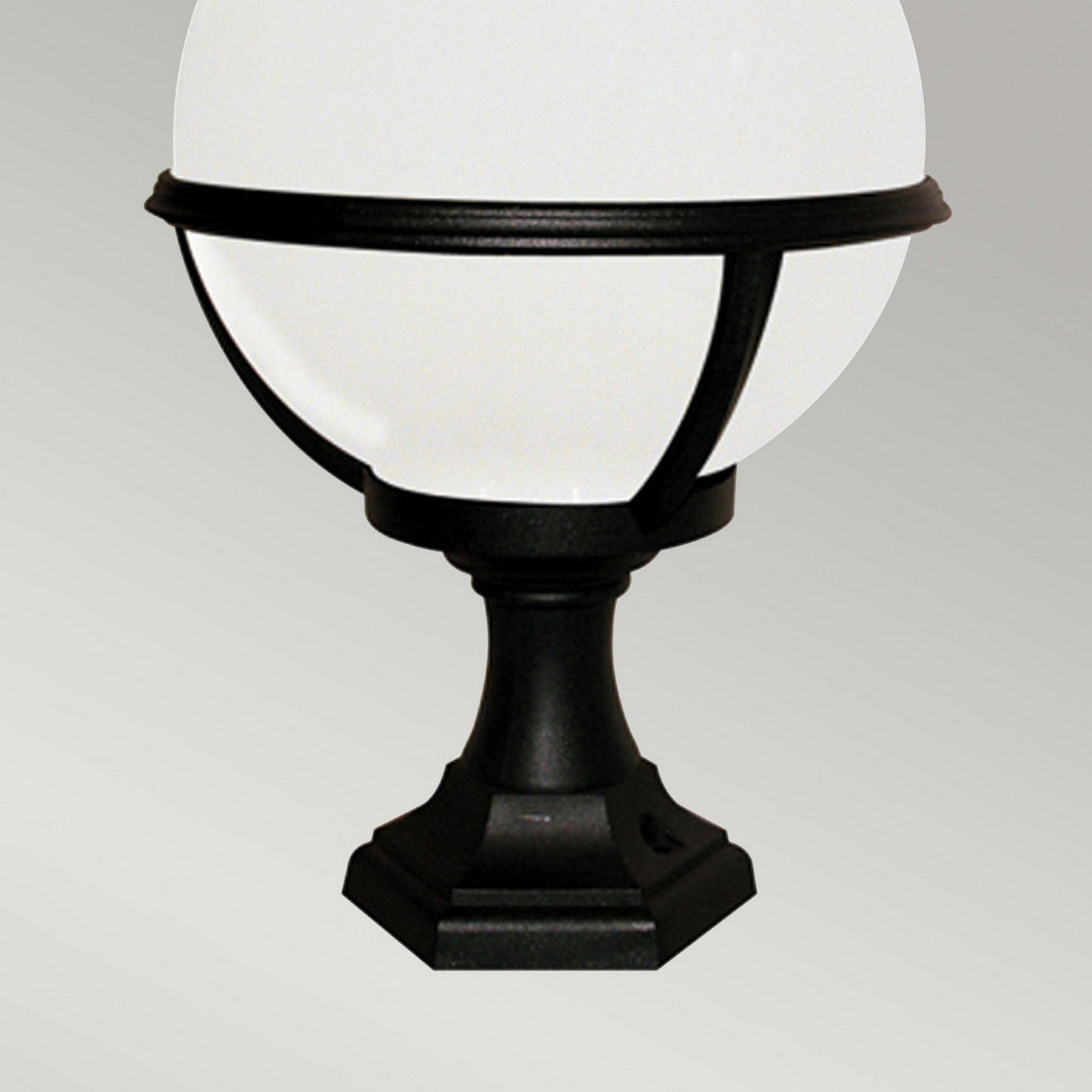 The Glenbeigh 1 Light Pedestal/Porch Lantern in black is corrosion-resistant and showcases a decorative design with a spherical white light fixture on a pedestal base, making it perfect for porch lighting against a neutral gray backdrop.