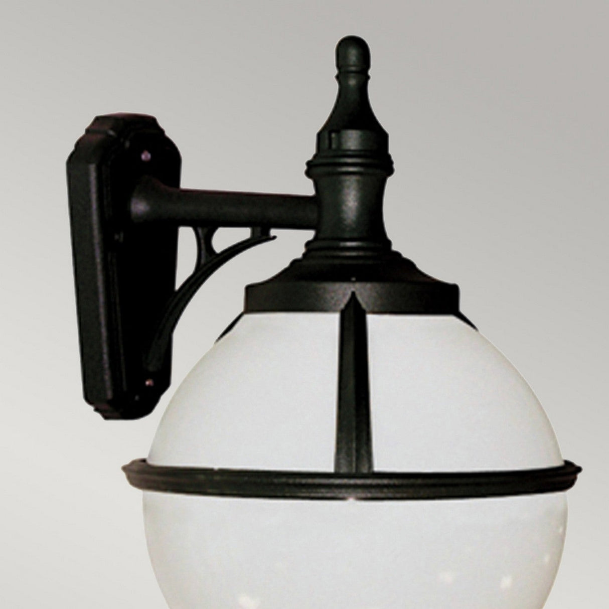 The Glenbeigh 1 Light Outdoor Wall Light in black features a round frosted glass globe and an IP44 rating for weather resistance, all presented against a plain gray background.