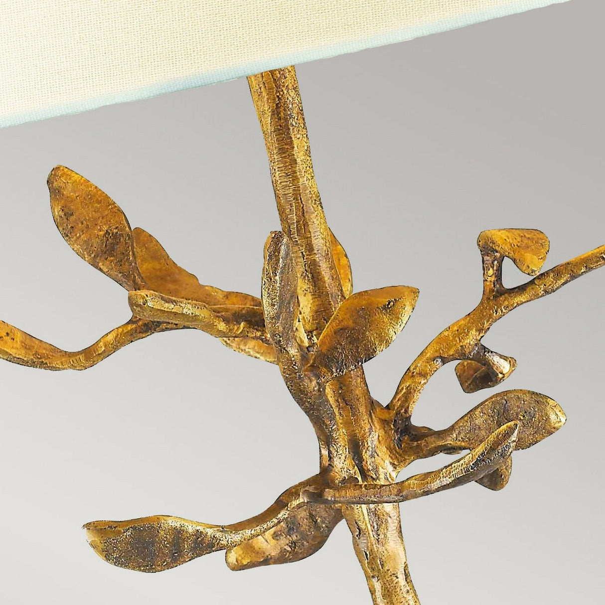 Close-up of the Audubon Park 1 Light Table Lamp - Gold, showcasing a sculptural base with intricately detailed metal branches in gold, designed with a tree motif. These branches extend upward, offering an elegant and artistic aesthetic against a neutral background.