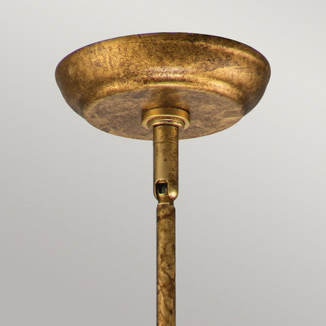 Close-up view of the gold leaf Sun King 1 Light Pendant with a connecting rod, showcasing a rustic, textured finish and starburst design, set against a plain, light background.