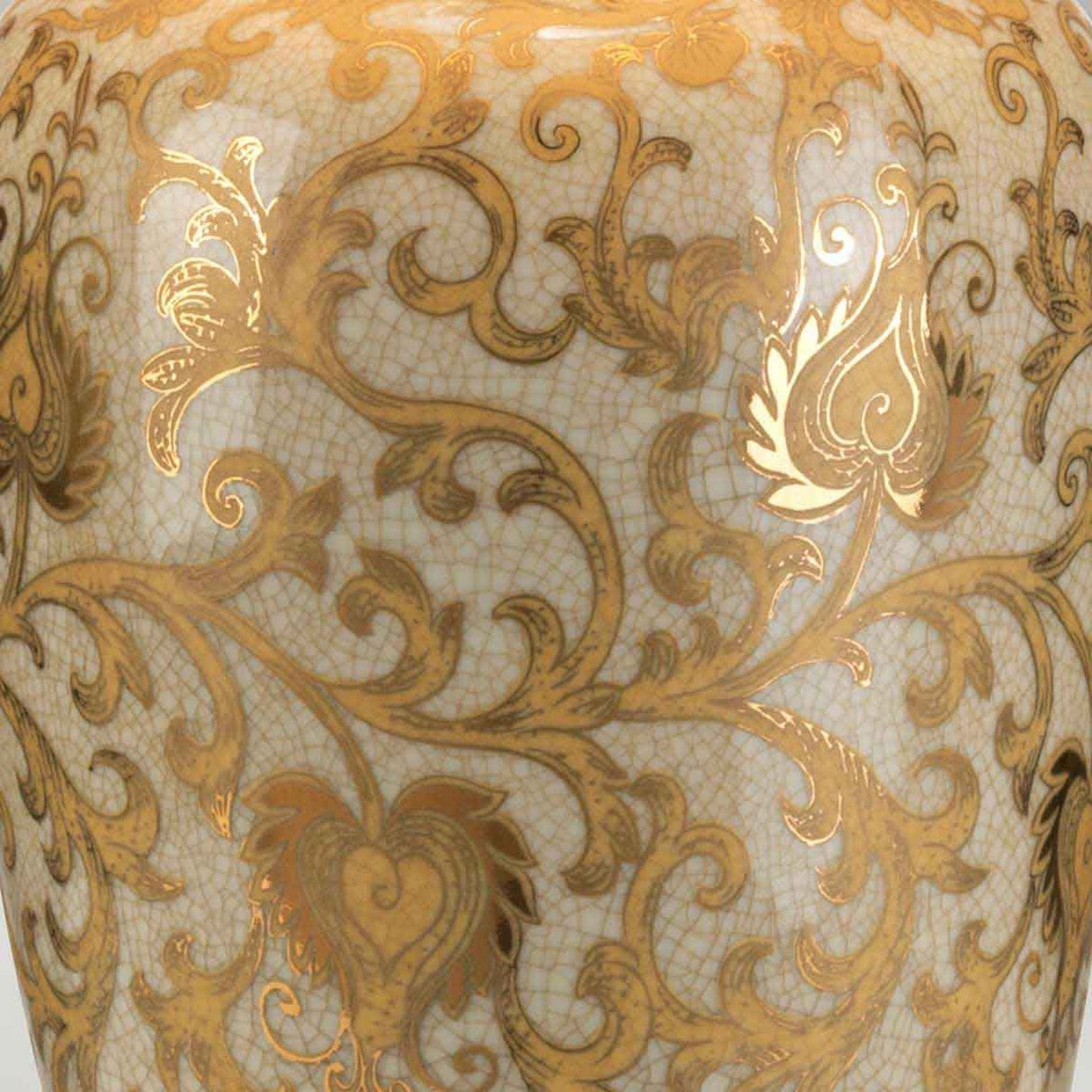 Close-up of the Gold Thistle 1 Light Table Lamp - Gold, highlighting its ornate ceramic base with intricate gold floral patterns against a textured, off-white background.