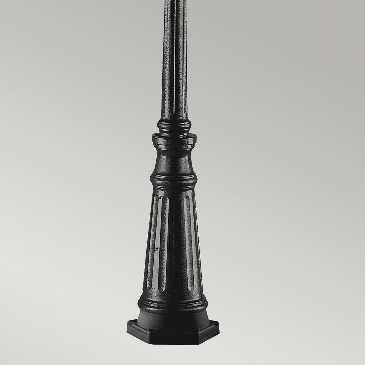 The Grampian 1 Light Lamp Post - Black is designed with an ornate base made from cast aluminium. It features a hexagonal bottom with decorative ridges, making it an ideal choice for enhancing outdoor lighting against a plain gray backdrop.