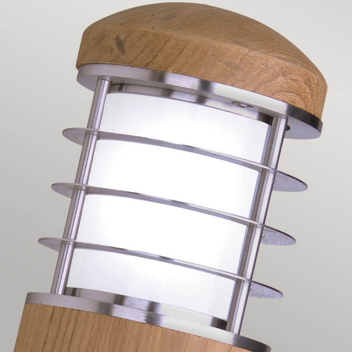 The Poole 1 Light Outdoor Wall Light in light brown offers a modern design with its wooden cap and base. It features marine grade stainless steel rings that encircle a frosted glass center, providing a contemporary aesthetic against a neutral backdrop. Additionally, its IP44 rating ensures durability in any weather conditions.