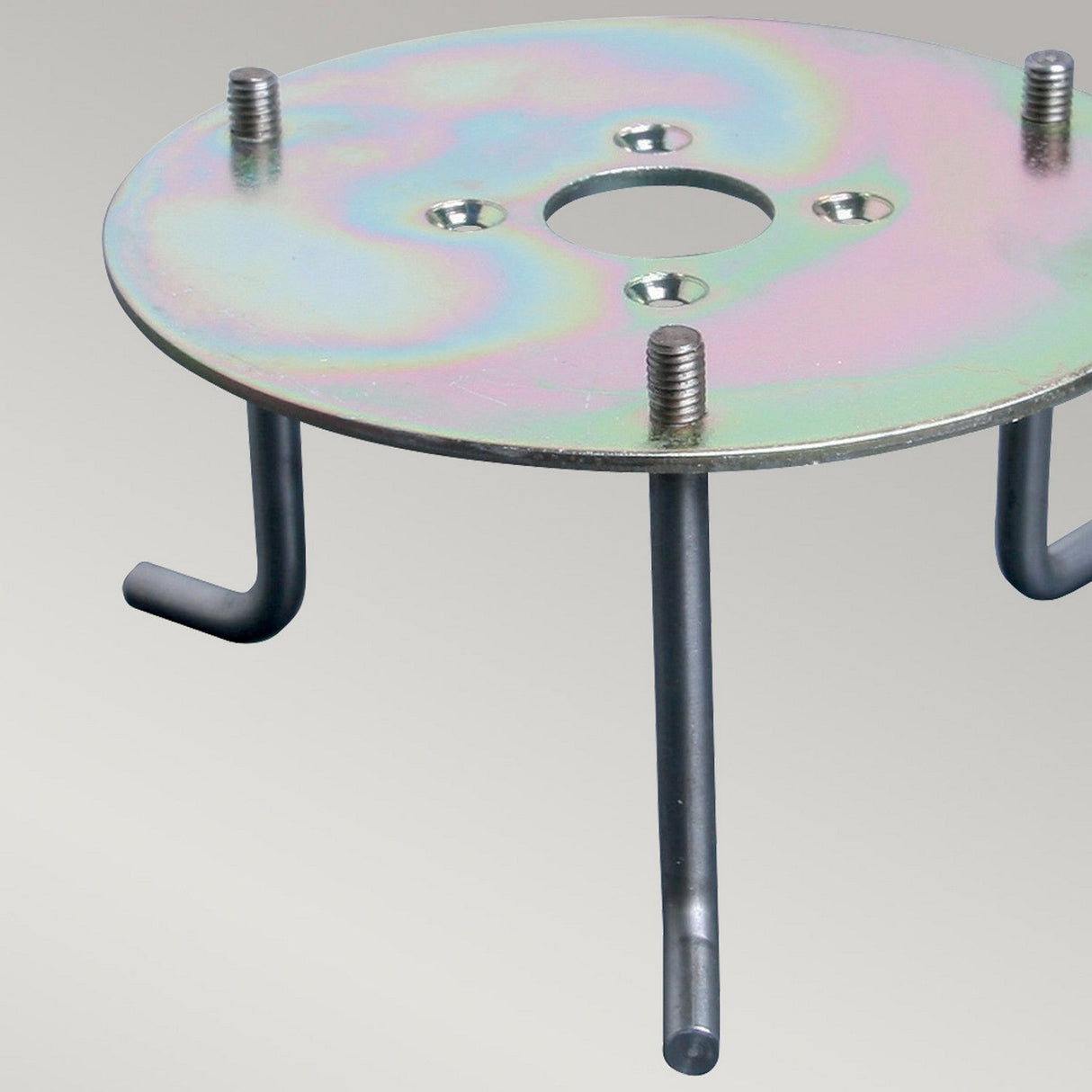 The Root for Sandbanks and Poole Bollards is a sturdy metal disc with a hole in the center, surrounded by four screw holes. It includes four metal rods extending downward at 90-degree angles and has a surface with a rainbow-like sheen.