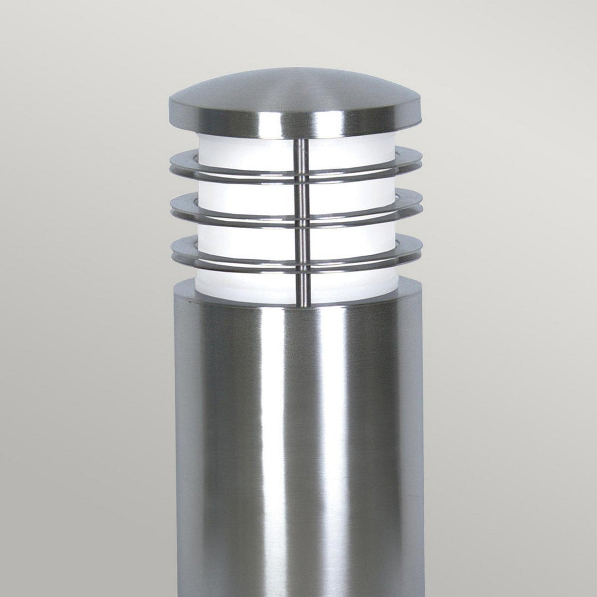 The Sandbanks 1 Light Mini Bollard - Silver is designed with a sleek cylindrical shape and crafted from marine-grade stainless steel. It features three circular metal bands, a dome-shaped top, and a white light diffuser, complemented by an unobtrusive light gray background that underscores its contemporary aesthetic.