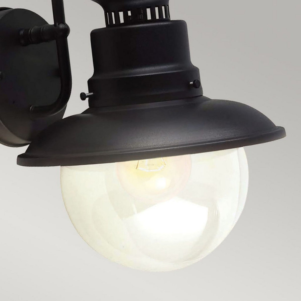 Close-up of the Shipston 1 Light Outdoor Wall Lantern in a classic black finish, featuring a round frosted glass shade. The bulb within casts a soft glow against a plain gray background.