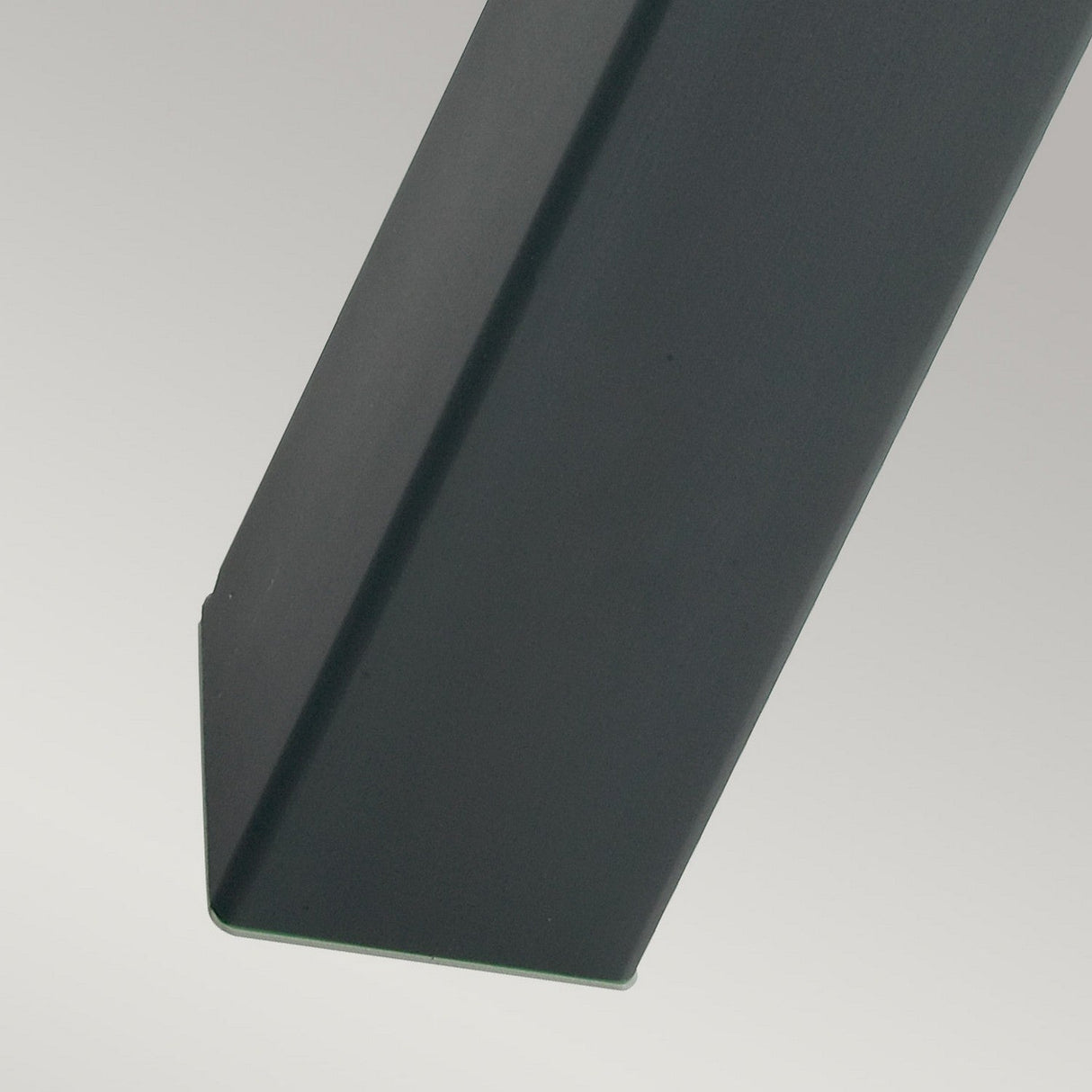 Close-up of a sleek, black, weather-resistant metallic bollard extending diagonally across a light gray background.