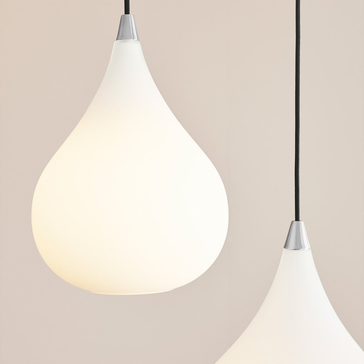 Drops Glass Pendant Light 23cm in Opal & Steel, teardrop-shaped opal glass shade with polished steel neck and black flex, shown paired against a light neutral background.