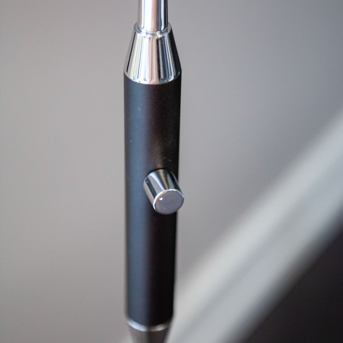 Close-up of the Vegas LED Floor Lamp in black, showing the matte black column with a chrome dial switch, and the base of the flexible gooseneck.