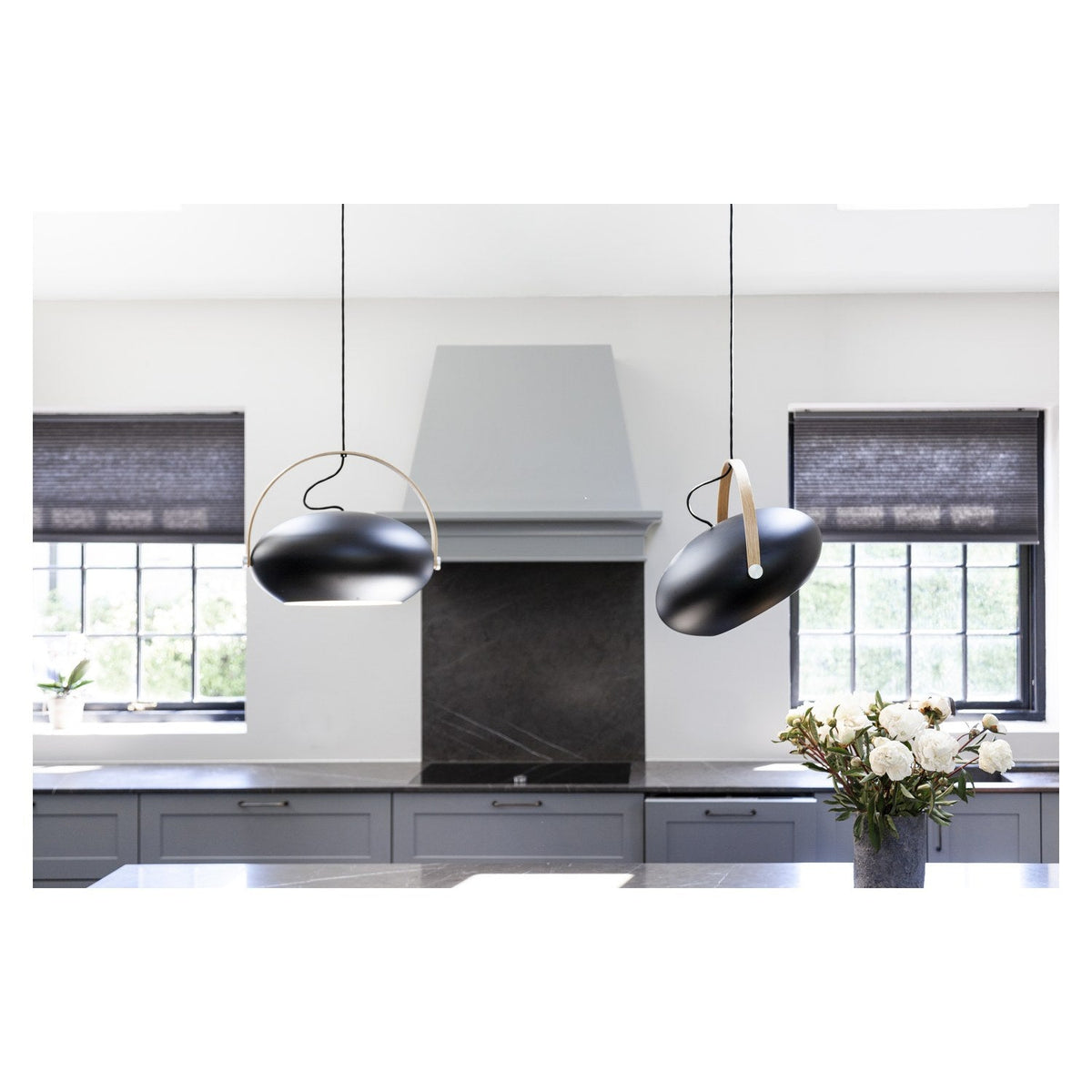 DC Pendant Light 40cm in black and oak, egg-shaped shade with curved oak handle strap, shown in pairs above a grey kitchen island with marble worktops.