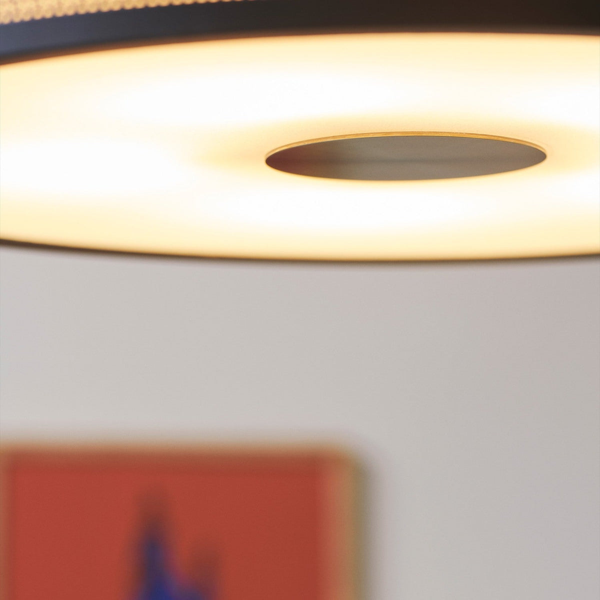 Close-up of the Frame 5 Light Flush Ceiling Light 43cm in black and antique brass, showing the opal diffuser glowing around a central brushed brass boss.
