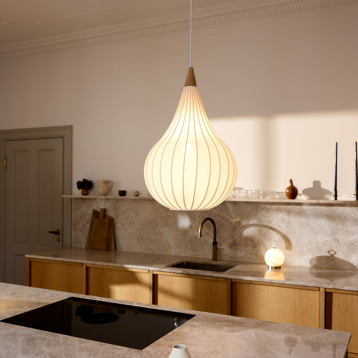 Drops Textile Pendant Light 38cm in white, onion-shaped opal fabric shade with fine grey ribs and pale wood cap, hanging over a marble kitchen island.
