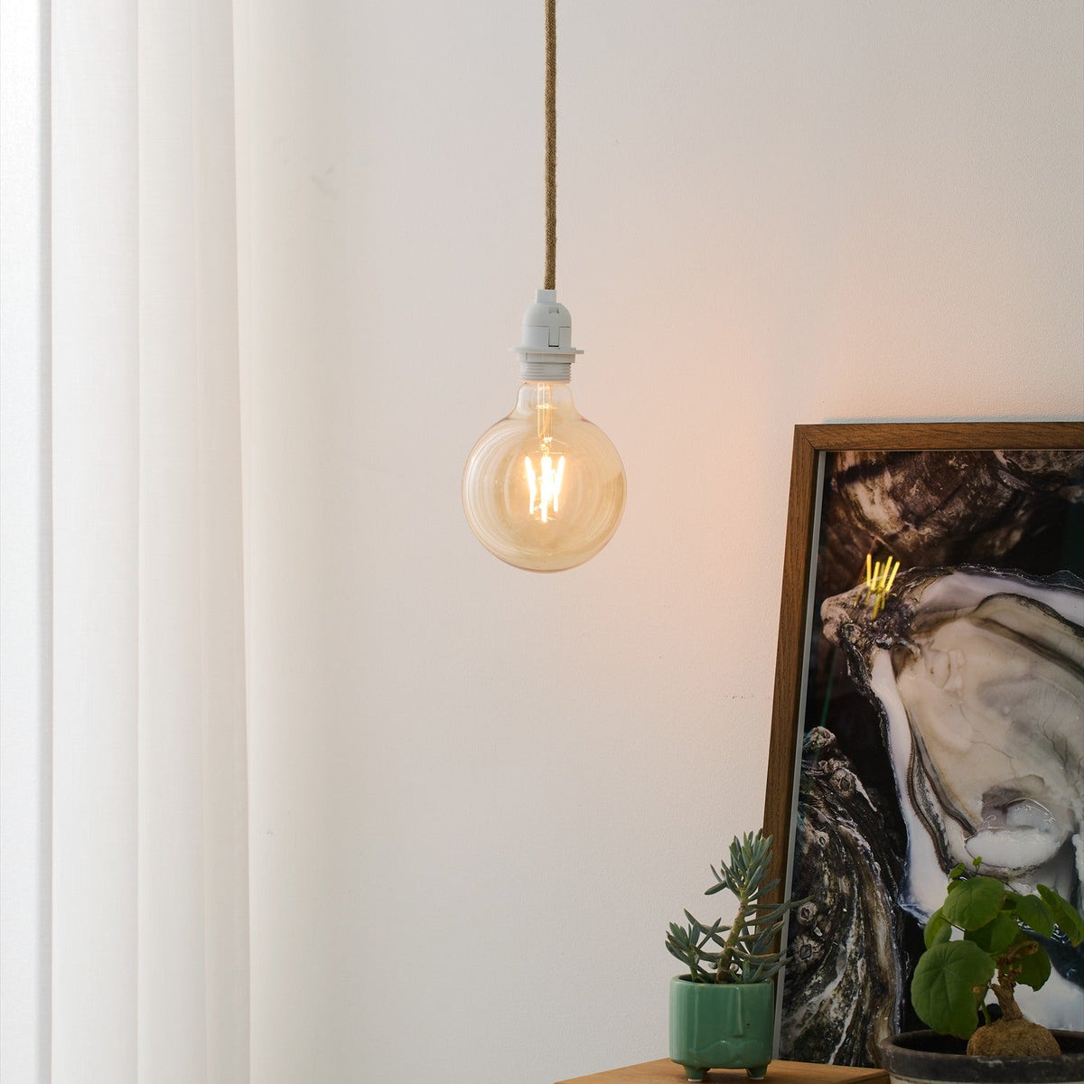 Basic Socket Textile Cable Cord Set 2m in natural braided fabric flex with a white moulded E27 lampholder, shown pendant-style with a globe bulb against a light wall.