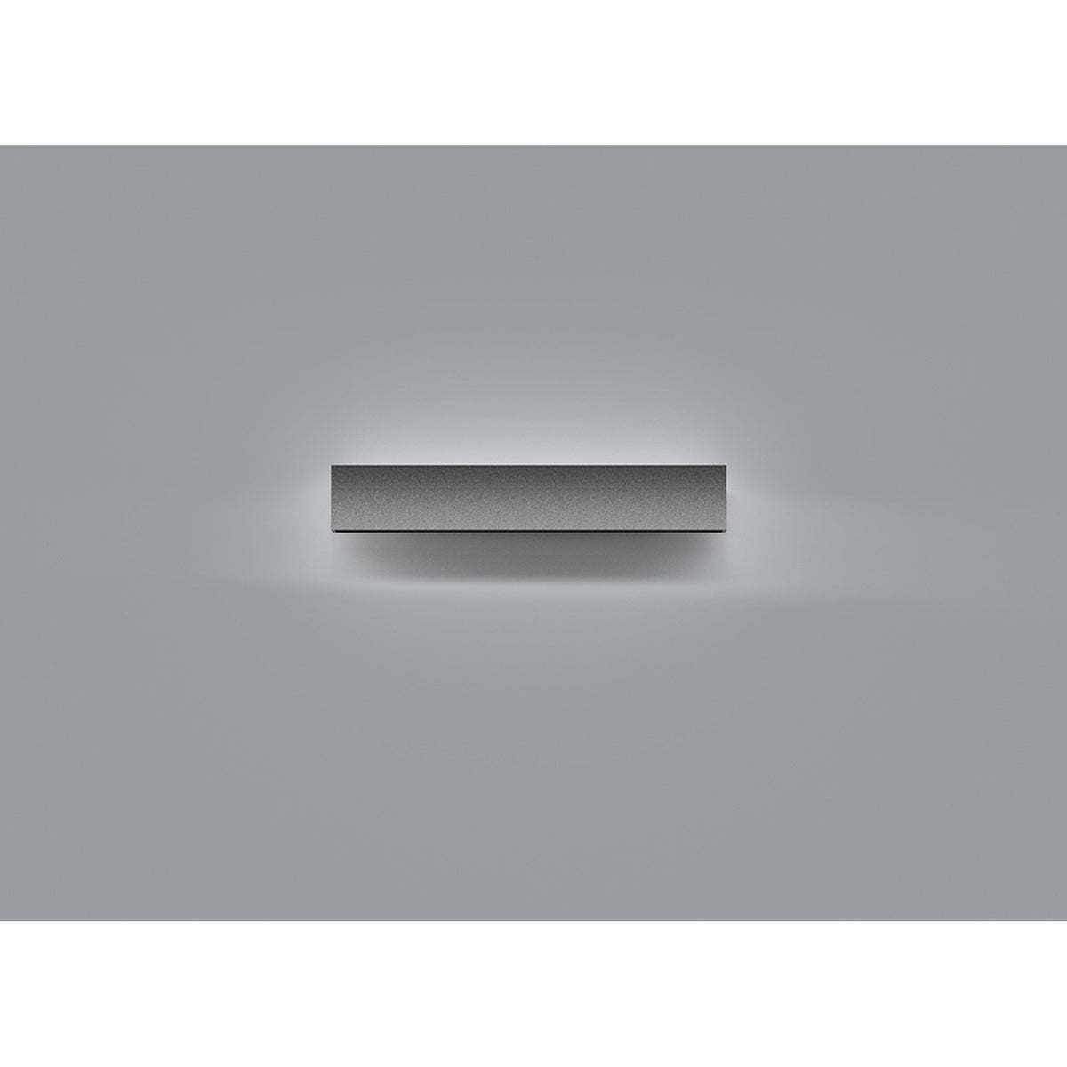 Hanok 41cm linear LED wall light in matt black, mounted horizontally and casting a soft warm white glow across a plain grey wall.