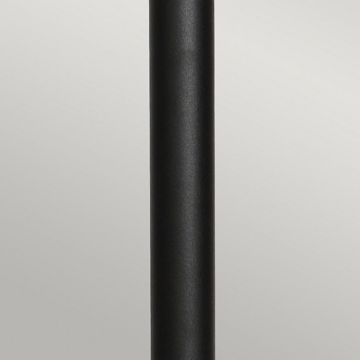 A close-up view of the Helsingor 1 Light Bollard Lantern with PIR in a sleek, vertical black design set against a neutral gray background. The lantern is centered in the image, showcasing its smooth, matte texture and emphasizing its IP44 rating for weather resistance.