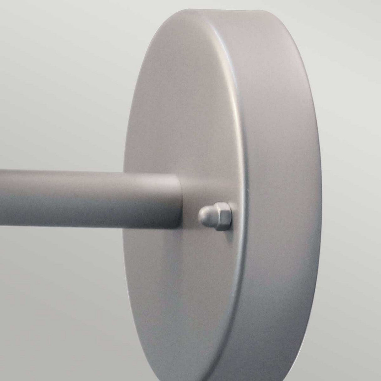 Close-up of the Helsingor 1 Light Outdoor Wall Light in silver, featuring a gray metal disc connected to a rod with a small bolt, all crafted from stainless steel. The background is a light, neutral color.