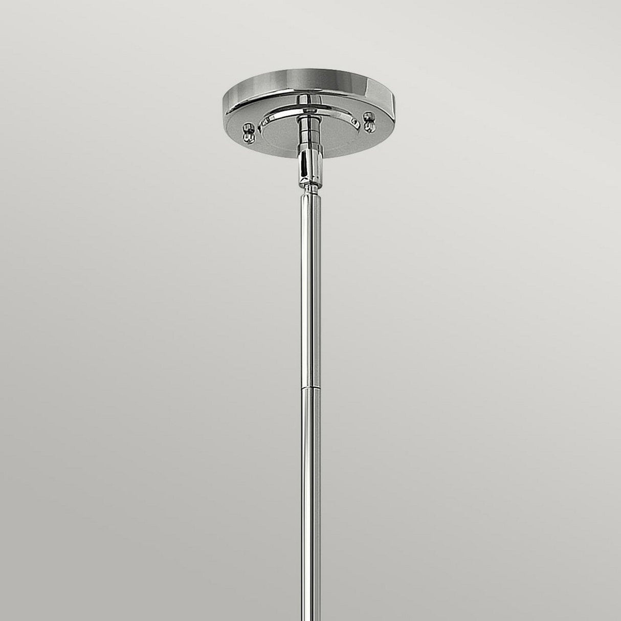 Close-up of the Amelia 1 Light Medium Pendant in chrome, showcasing its metallic finish with a round base plate and a vertical rod extending downward, set against a light gray background. This modern lighting fixture embodies both style and sophistication.