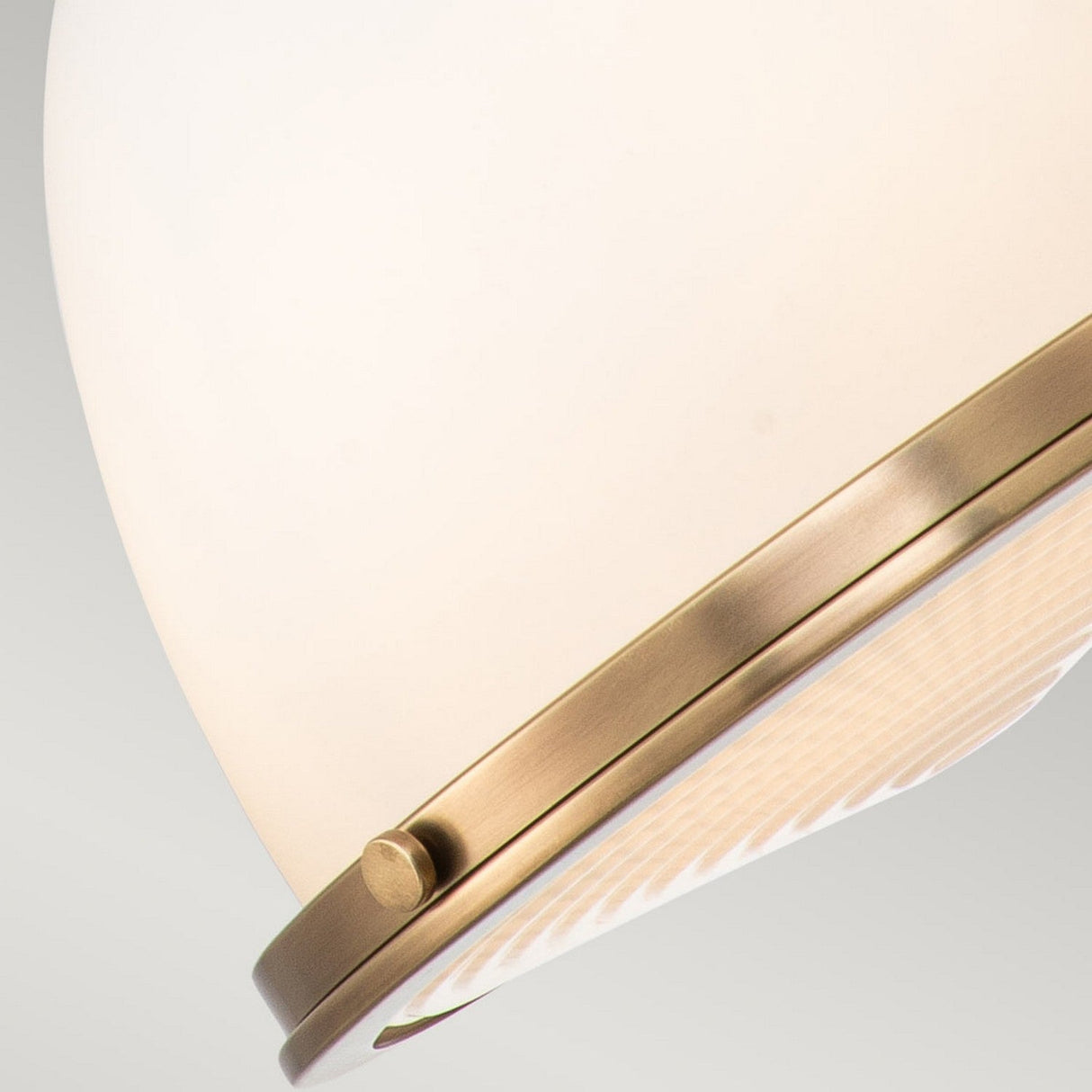 Close-up of the Amelia 1 Light Medium Pendant in brass, featuring a frosted glass shade, set against a light gray background. The sleek design seamlessly combines modern farmhouse flair with vintage charm.