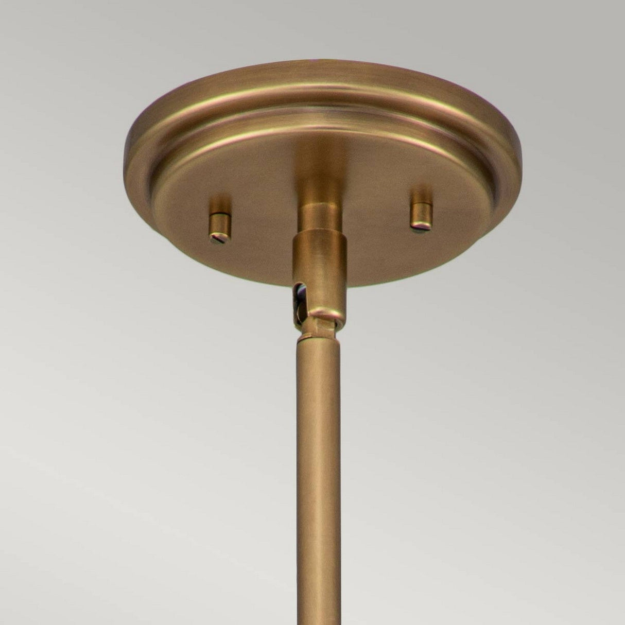 Close-up of the Amelia 1 Light Mini Pendant - Brass ceiling light fixture, highlighting the round ceiling mount and a straight rod extending downward. The smooth, modern design features an opal glass dome that provides a warm metallic finish against a plain, light-colored background.