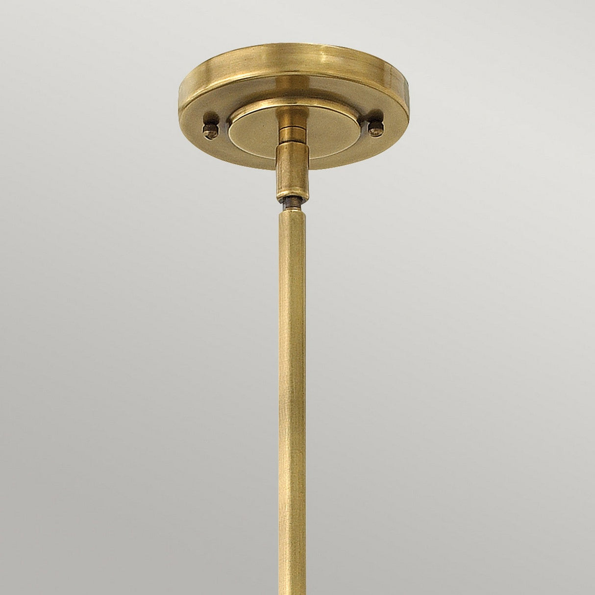 Close-up of the Amelia 1 Light Mini Pendant - Bronze, highlighting a bronze ceiling light fixture with an opal glass dome and a rod extending downwards against a plain gray background. The fixture features a circular mount with a simple, elegant design.