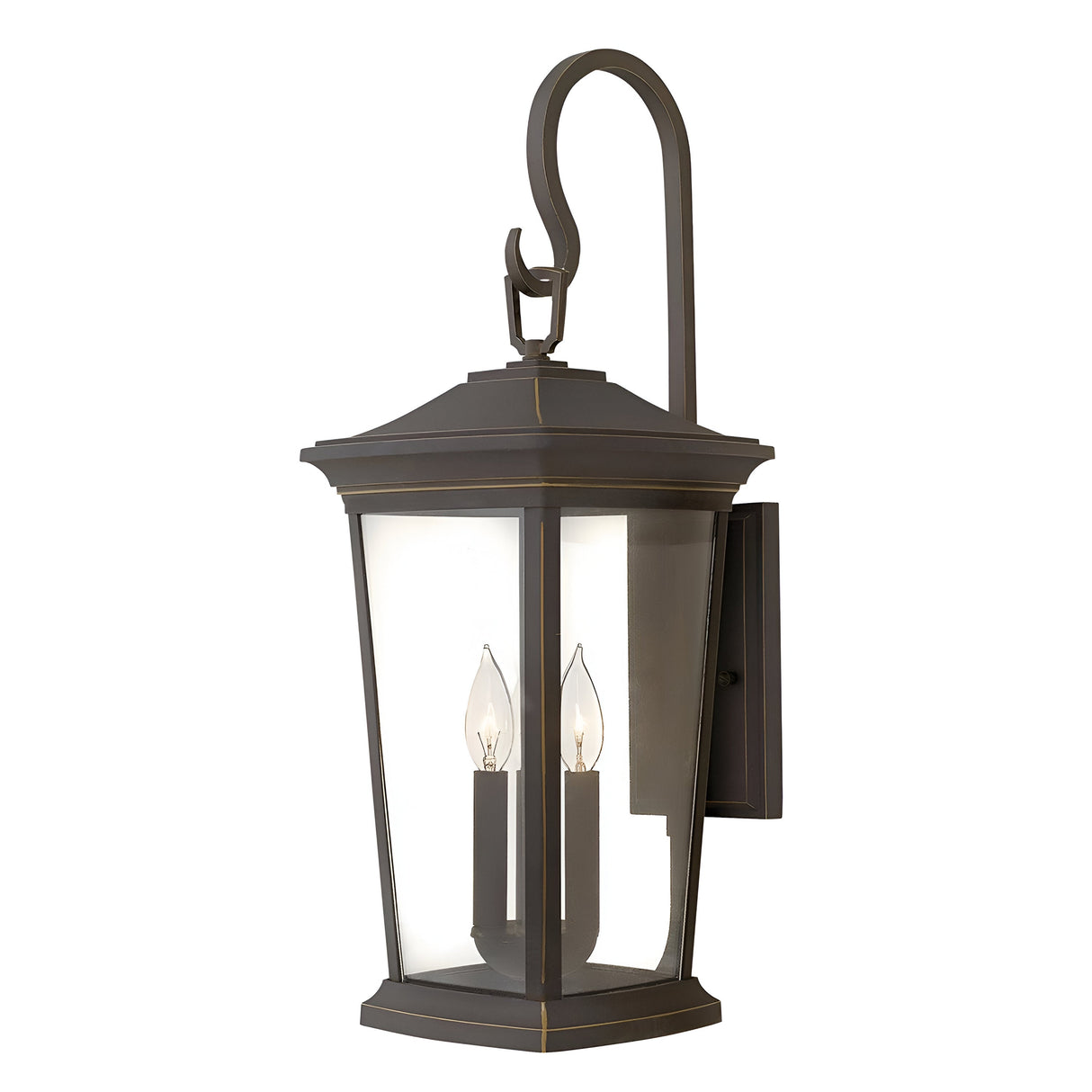 The Bromley 3 Light Outdoor Large Wall Lantern in bronze features a durable aluminum construction and a classic curved hook design. Its rectangular frame, combined with clear glass panels, elegantly encases three candle-like bulbs, offering an exquisite vintage charm.