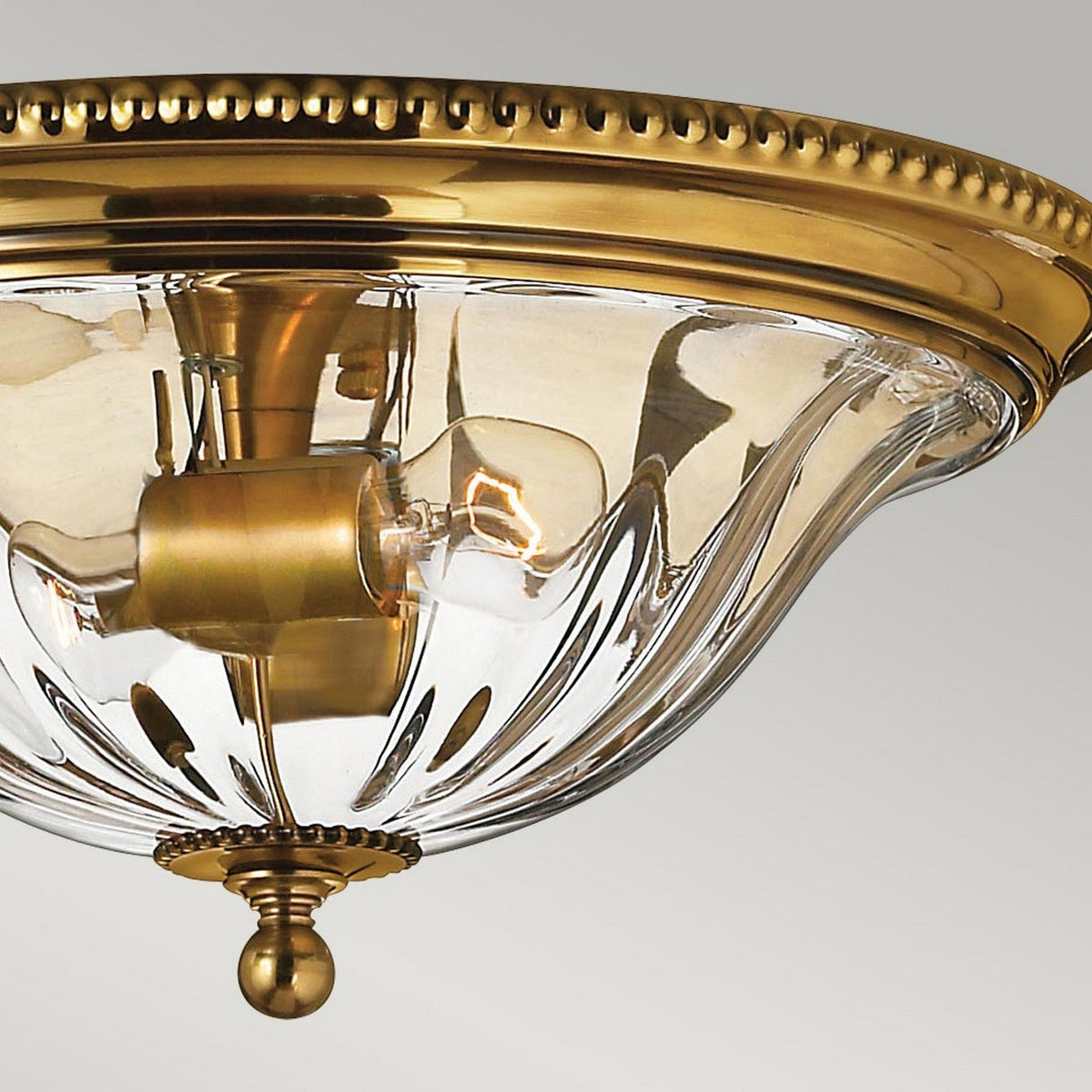 Introducing the Cambridge 2 Light Flush in Burnished Brass, this decorative ceiling light fixture showcases a transparent glass dome and an exposed bulb. Its design seamlessly blends New England decor with classic and modern elements, providing an elegant lighting solution.