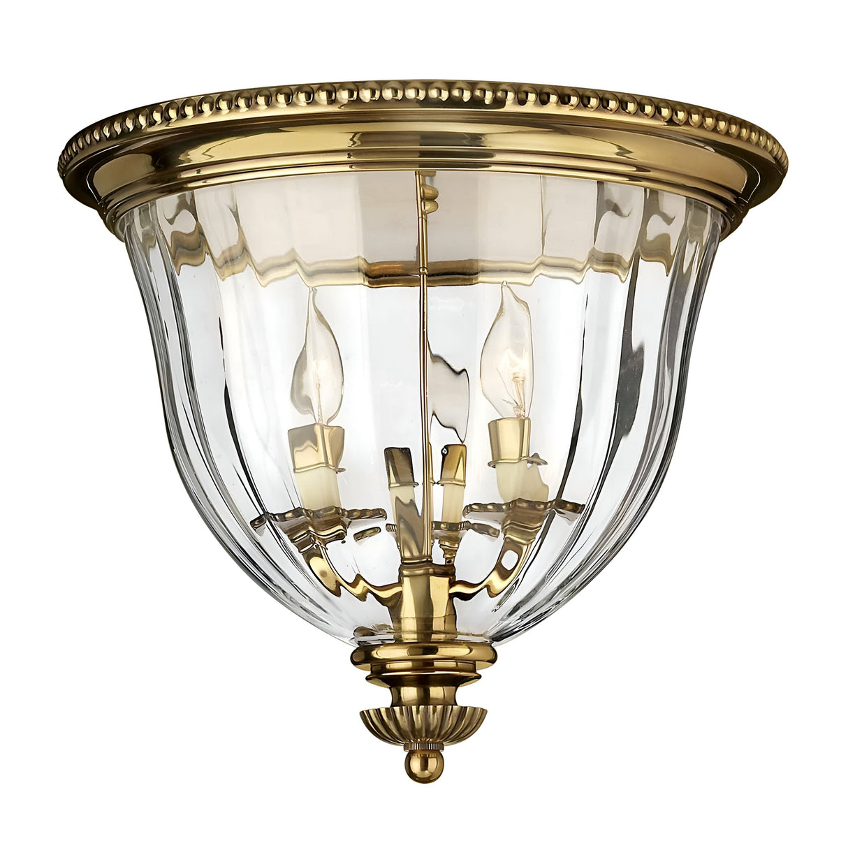 The Cambridge 3 Light Flush - Burnished Brass is a New England style ceiling fixture designed with clear glass panels and three candle-style bulbs. It boasts an elegant, vintage-inspired appearance, showcasing a decorative brass rim and intricate detailing at its base.
