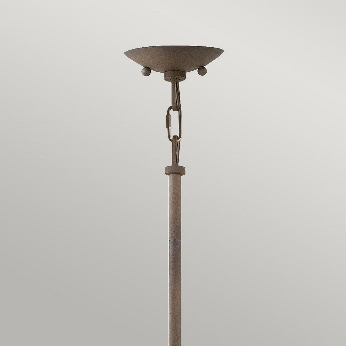 A close-up of a chic, contemporary floor lamp featuring a simple vertical pole and an elegant bowl-shaped shade at the top is set against a plain gray background. It exudes rustic charm with vintage iron details that are comparable to those found in the Carson 3 Light Outdoor Chandelier in Vintage Iron.