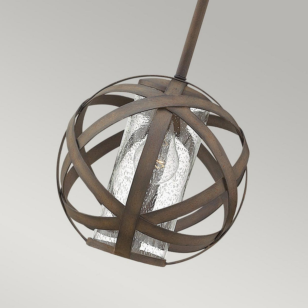 The Carson 1 Light Outdoor Pendant Light - Vintage Iron features a spherical design with dark metal bands surrounding a clear textured glass cylinder. Ideal for outdoor areas, it holds a single bulb and hangs gracefully against a plain gray backdrop.