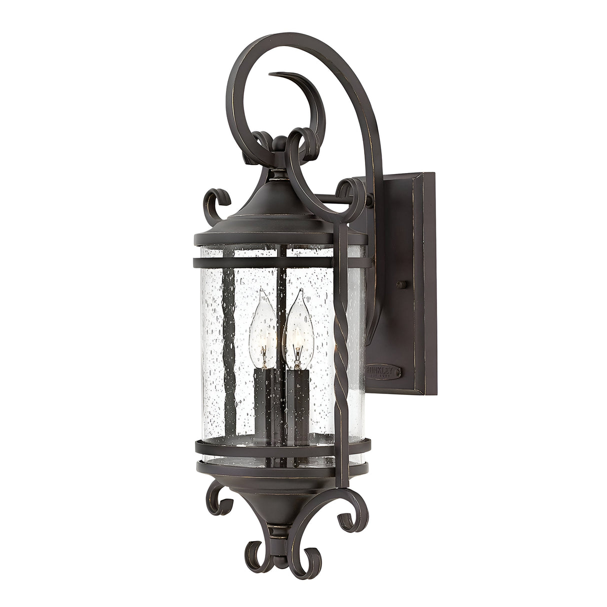 The Casa 2 Light Outdoor Wall Lantern in black features a wrought iron design with curled accents and clear glass casing, beautifully displaying two candle-shaped bulbs. It seamlessly blends traditional and rustic charm, making it an ideal choice for exterior lighting.