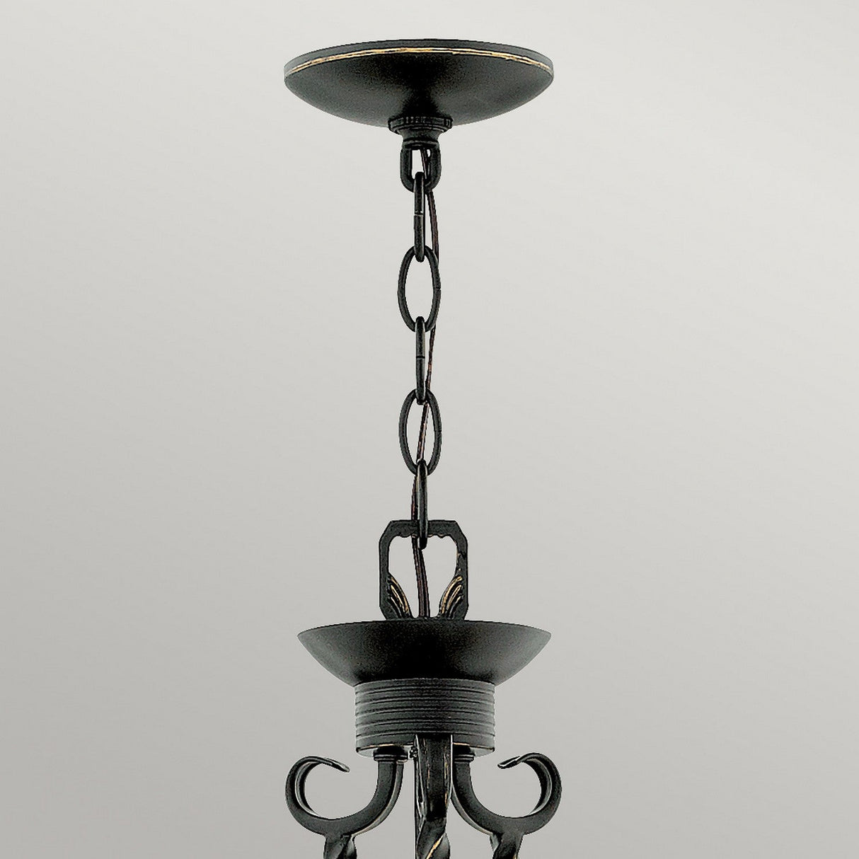 Close-up of a black metal ceiling light fixture with a chain hanging from the ceiling mount. The Casa 3 Light Chandelier - Black showcases decorative elements and a vintage design, complemented by seedy glass shades, set against a neutral background.