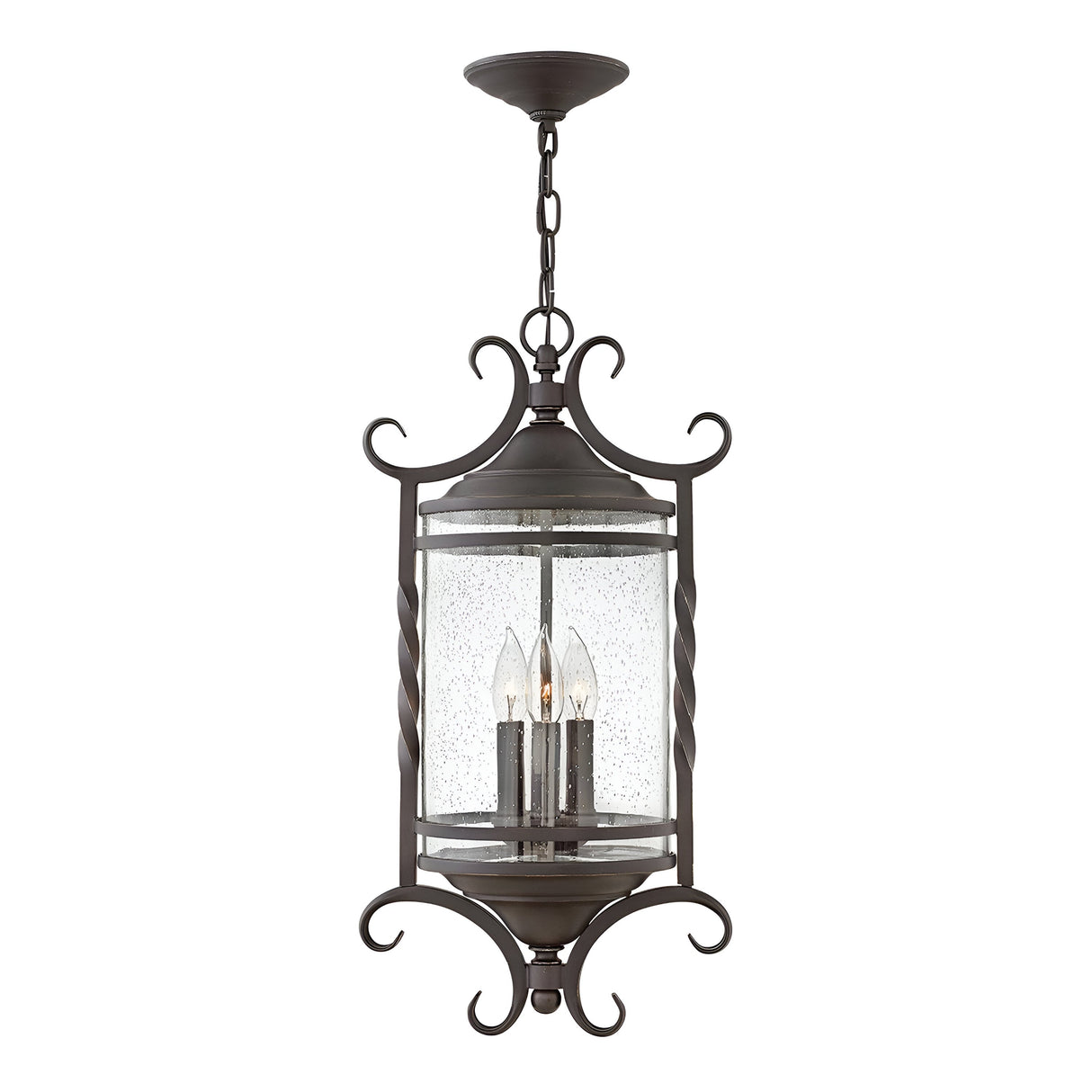 The Casa 3 Light Outdoor Chain Lantern in black features a decorative frame with intricate pierced metalwork, showcasing a cylindrical clear seedy glass enclosure that houses three candle-shaped light bulbs.