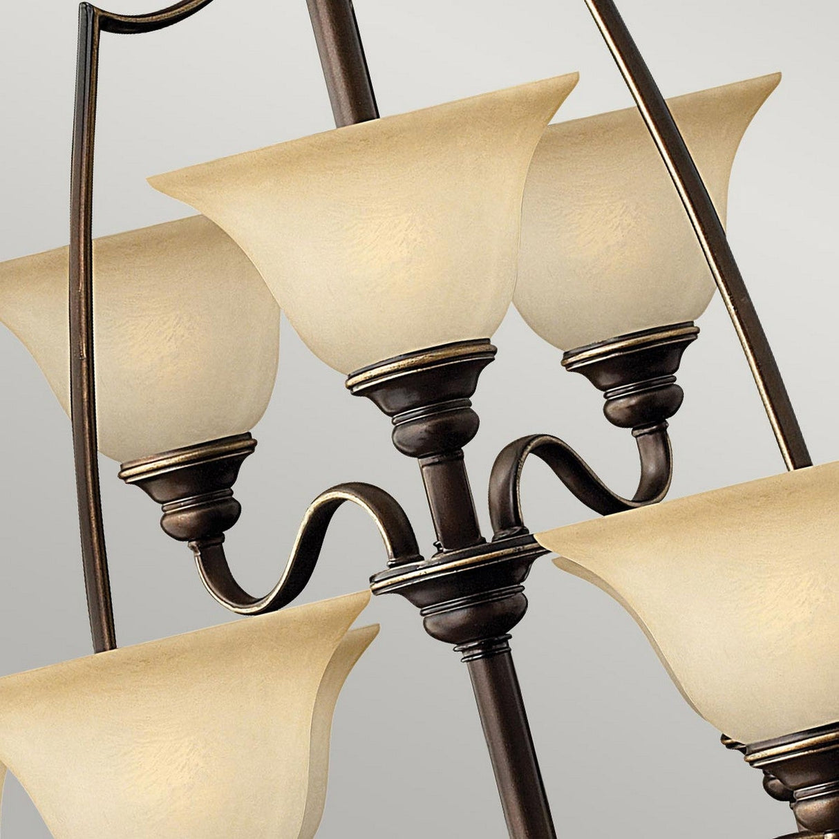 Close-up of the Cello 15 Light Chandelier in antique bronze finish, featuring six upward-facing vintage faux alabaster glass shades. The lamps are symmetrically arranged, highlighting a classic and sophisticated design against a neutral background.