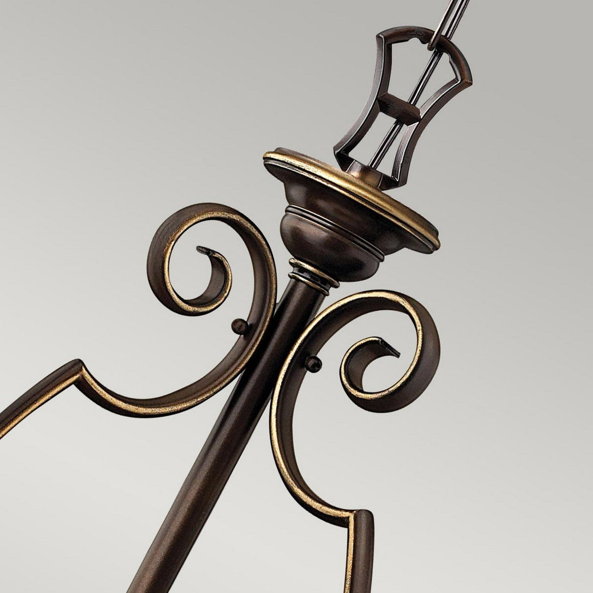 Close-up of the Cello 6 Light Chandelier in antique bronze, highlighting its elegant scrollwork design reminiscent of a vintage chandelier, set against a plain background.