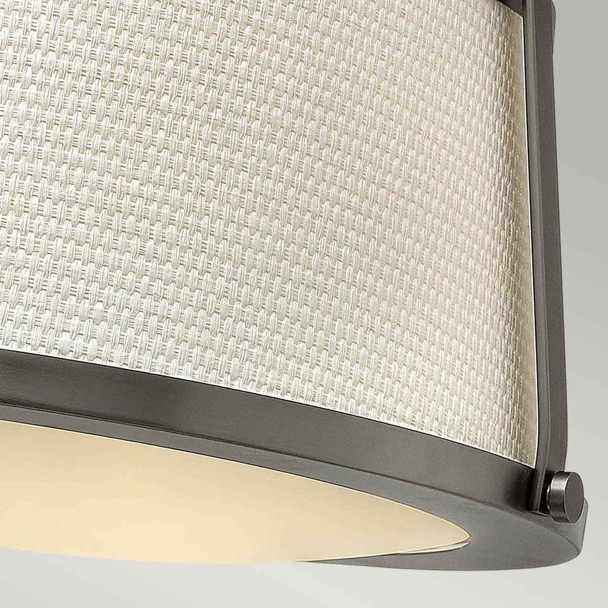 Close-up of a contemporary lampshade with a woven, textured design in light beige linen, bordered on the top and bottom by sleek, dark metal frames in antique nickel, characteristic of the Charlotte 3 Light Semi Flush - Antique Nickel With Linen Shade.