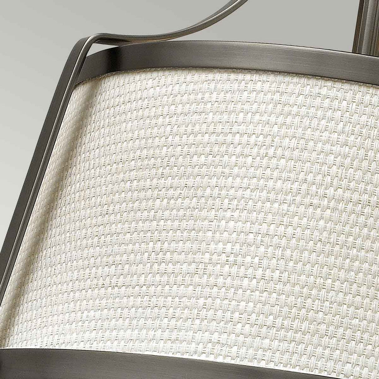 A detailed look at the Charlotte 3 Light Semi Flush reveals its modern lampshade featuring a woven texture. The linen shade is elegantly outlined by edges of antique nickel, contributing to a sleek and contemporary aesthetic. The light-colored fabric and brushed finish metal perfectly capture the design's graceful elegance.