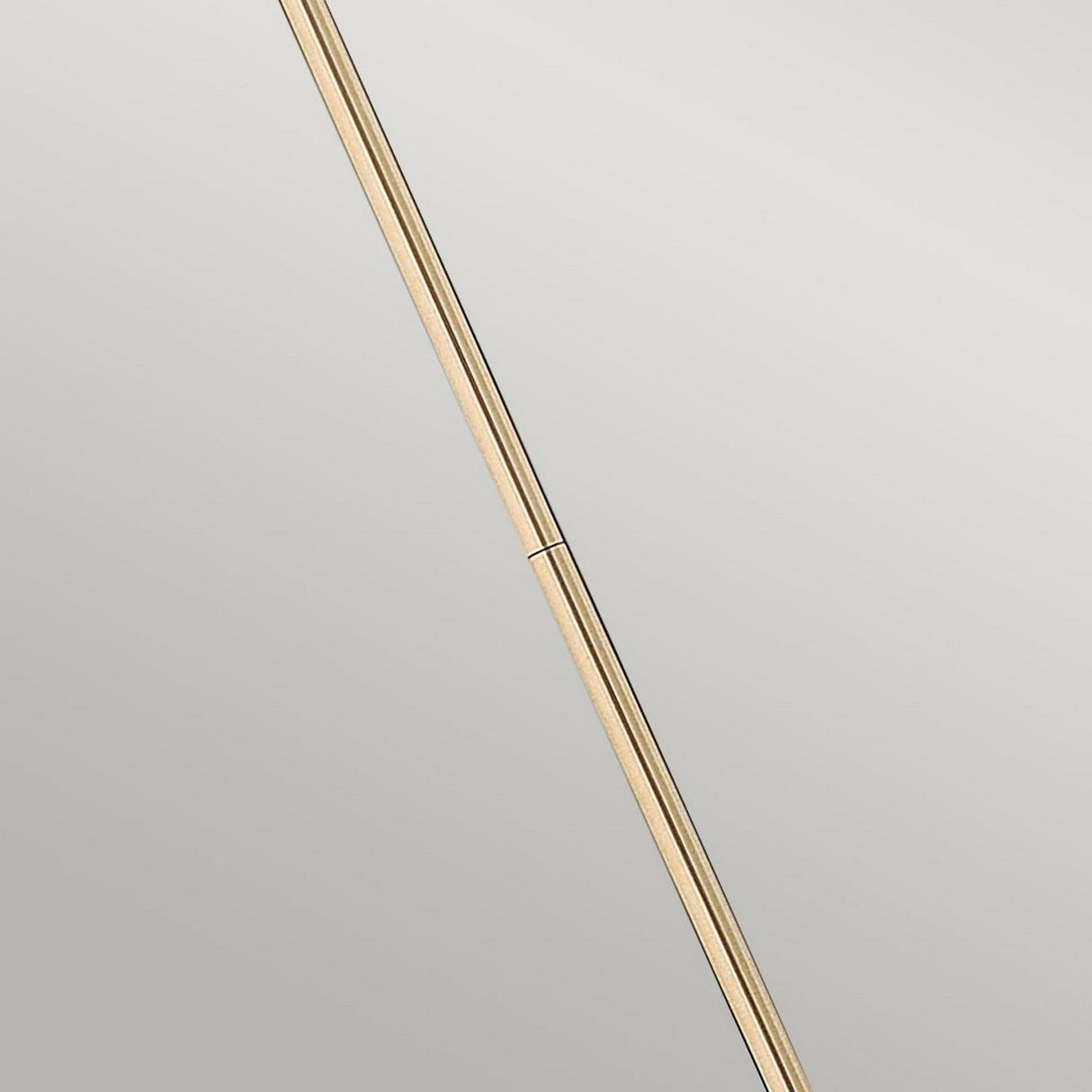 A minimalist image showcases the Congress 1 Light Clear Glass Pendant in a brushed caramel finish, positioned diagonally against a gray background. The pendant's smooth texture and delicate shadows offer an elegant contrast.