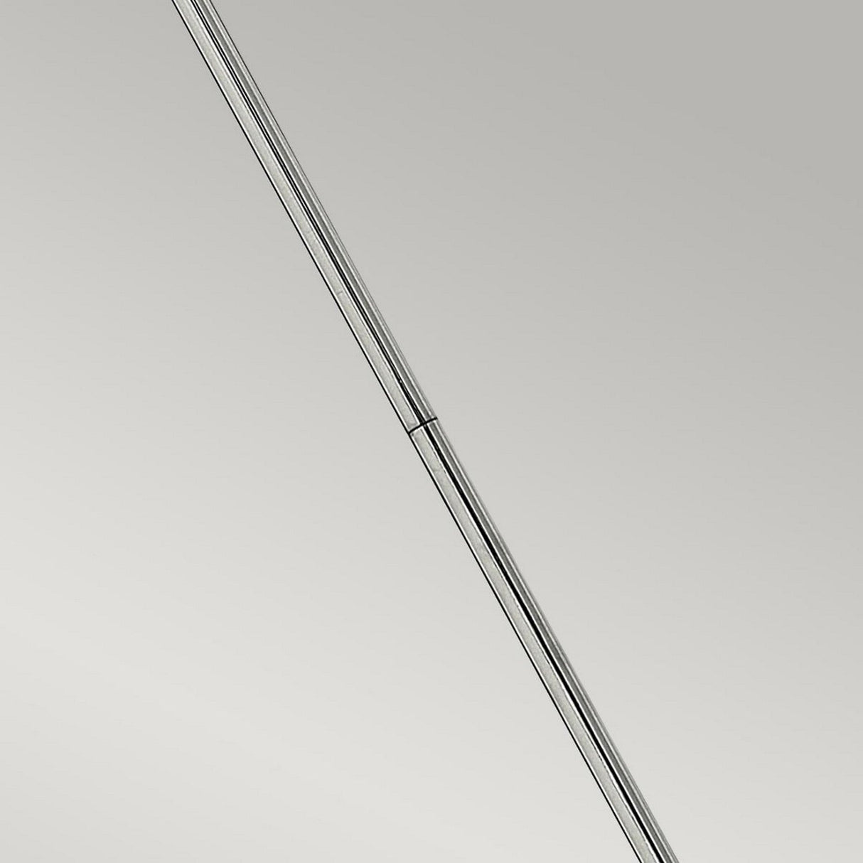A close-up image of a sleek, minimalist pen with a chrome finish is positioned diagonally against a neutral gray background, echoing the elegance of the Congress 1 Light Clear Glass Pendant in Chrome.
