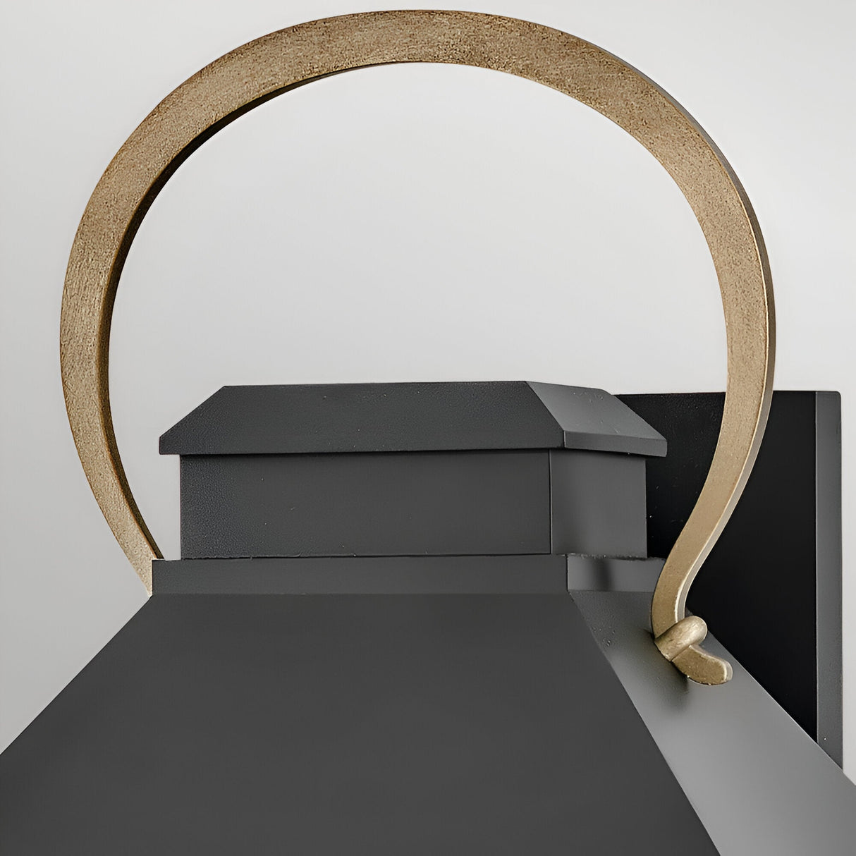 A close-up of the Dawson 1 Light Outdoor Large Wall Lantern in Black Oxide, featuring a gold arched handle, highlights its stylish exterior lighting design against a plain light background.