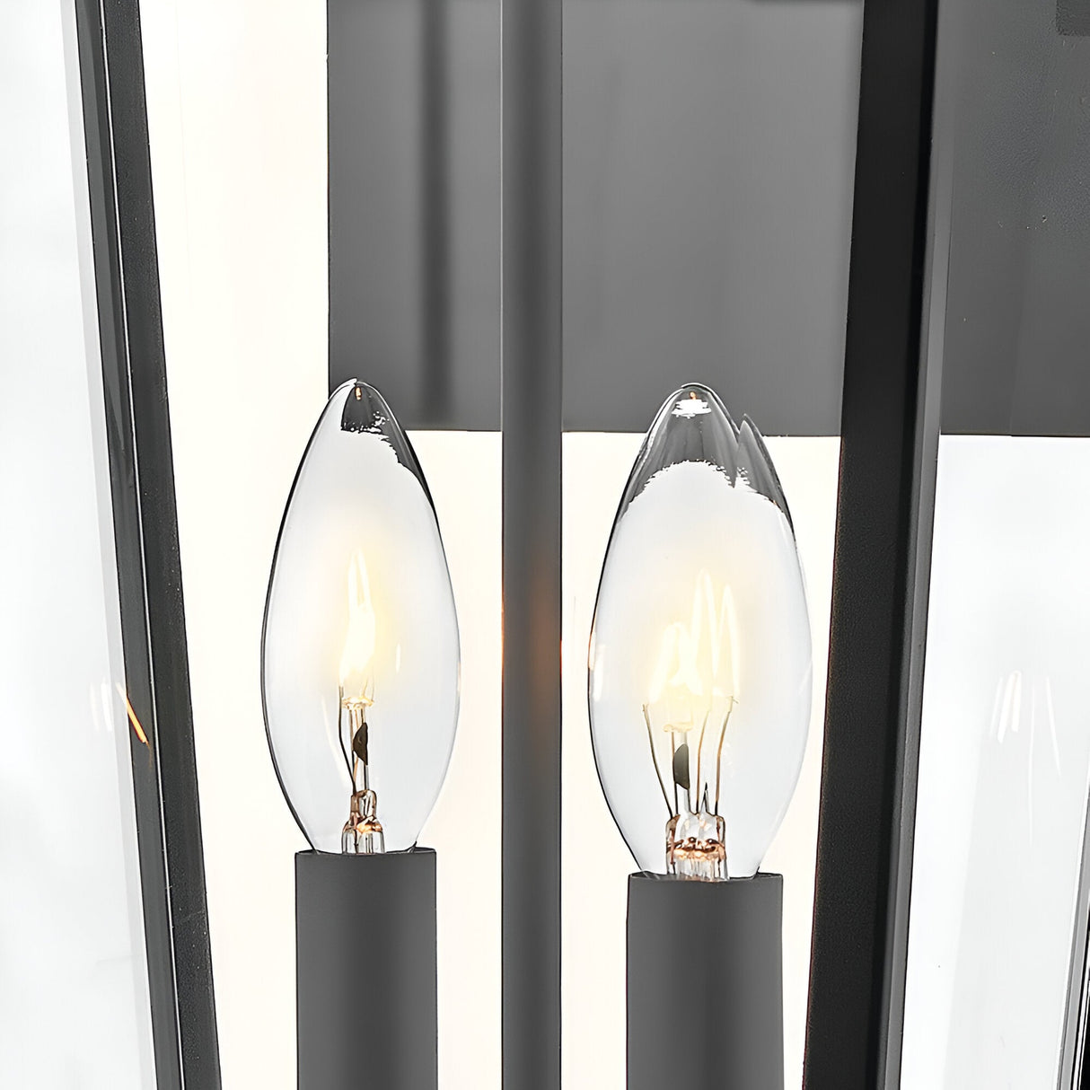 Close-up of Dawson 1 Light Outdoor Large Wall Lantern in Black Oxide: two candle-style bulbs in black sockets, encased by clear glass panels—offering a modern, elegant solution for stylish exterior lighting.