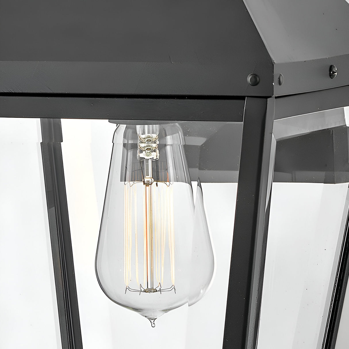 The Dawson 1 Light Outdoor Medium Wall Lantern in Black Oxide features a clear glass bulb with visible filaments, set in a sleek metal frame and glass panels—ideal for stylishly enhancing your patio lighting.