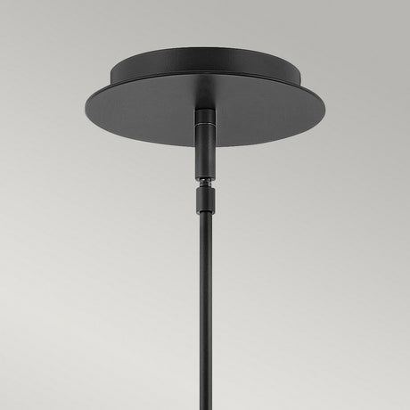 Close-up of the Dax LED Mini Pendant - Black, a modern lighting fixture with a sleek, metallic finish set against a neutral gray background. The black ceiling-mounted rod features a circular base and is vertically attached, providing energy-efficient illumination.