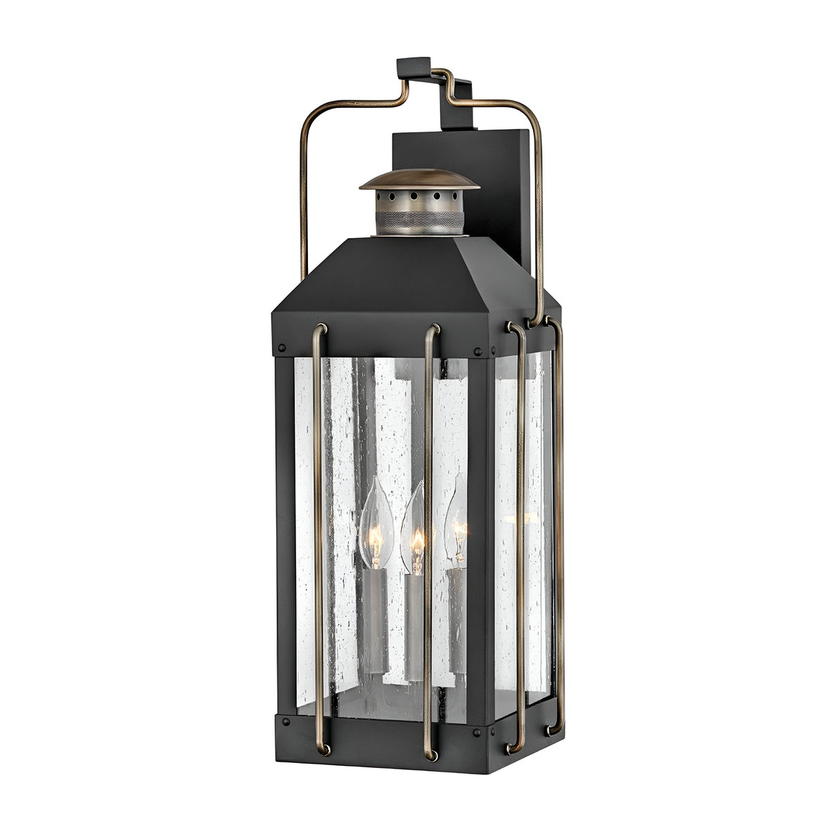 The Fitzgerald 3 Light Outdoor Large Wall Lantern in Black with Burnished Bronze is a vintage-style outdoor wall fixture crafted from durable aluminum. It features a black metal frame with clear glass panels that enclose three candle-like bulbs, hanging vertically to blend classic rustic design with industrial lighting, offering a timeless touch to your home exteriors.