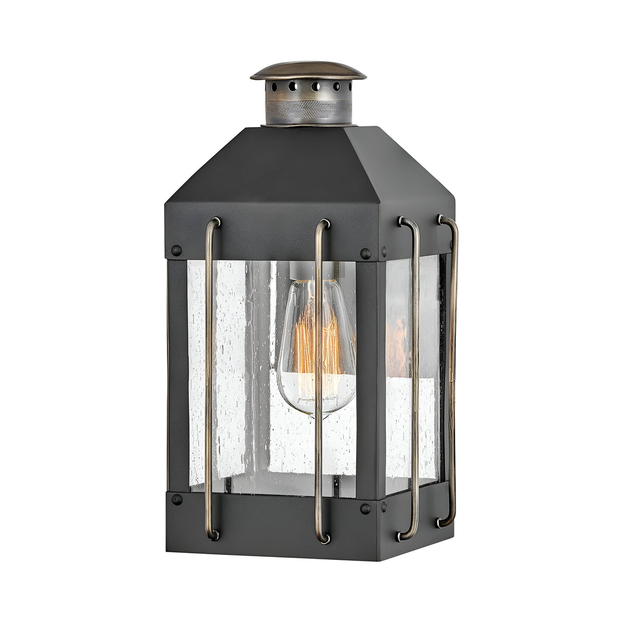 The Fitzgerald 1 Light Outdoor Small Wall Lantern in black with burnished bronze showcases a rustic industrial design. It features a rectangular metal frame paired with clear glass panels. The visible vintage-style bulb emits a warm glow, and the durable aluminum accents contribute to its classic charm.