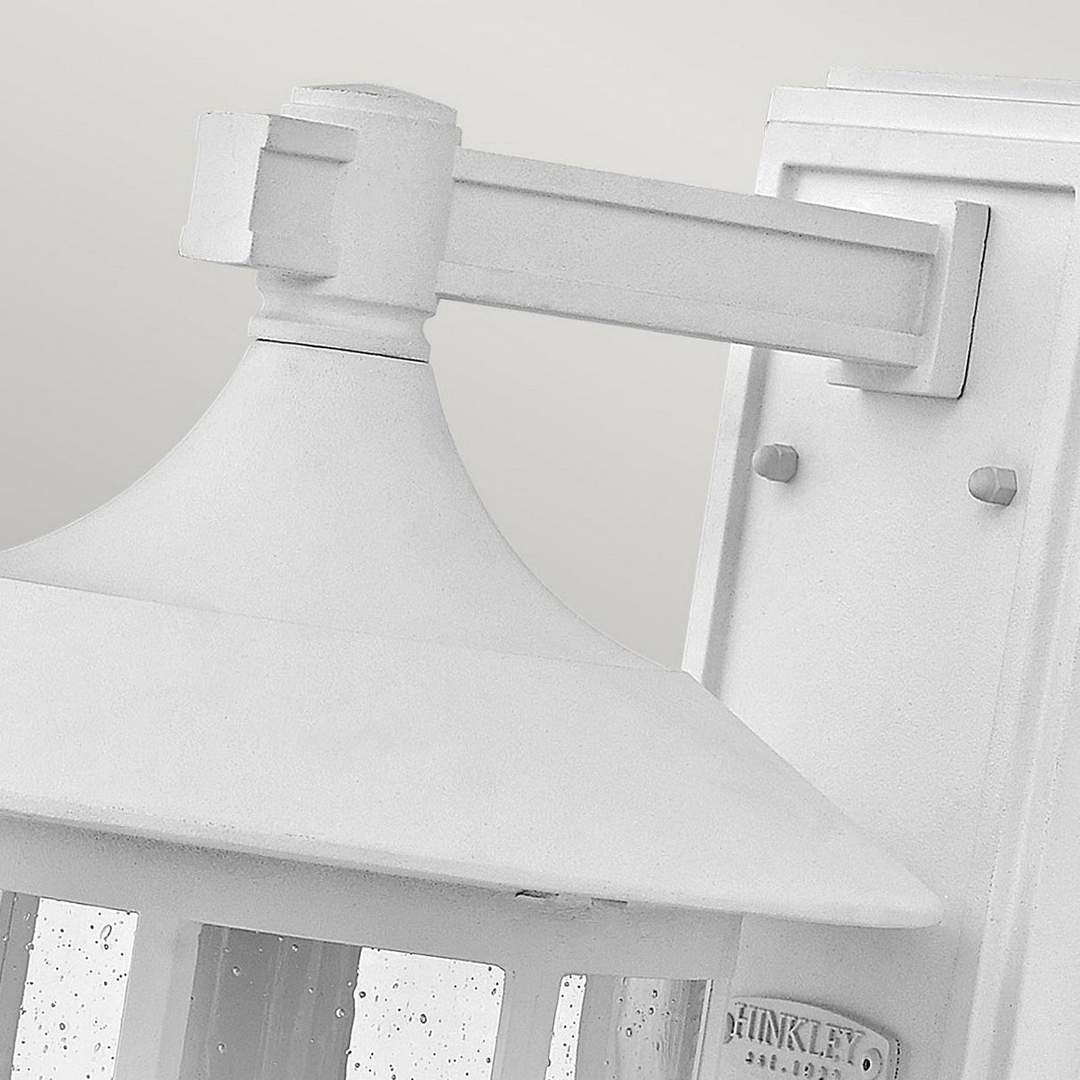 Close-up of the Freeport 1 Light Outdoor Large Wall Lantern in white, featuring a rectangular mount and a sloped top. This durable, weather-resistant design showcases clear seeded glass panels with a texture of small bubbles, set against a softly neutral background.