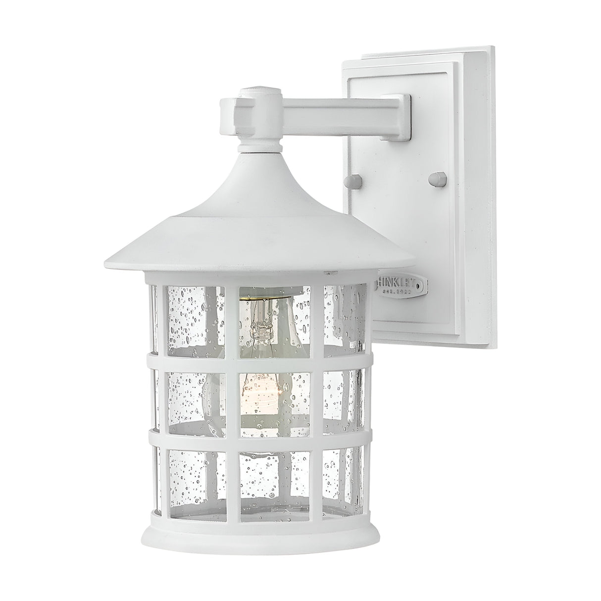 The Freeport 1 Light Outdoor Small Wall Lantern in white features a clear glass cover with a grid pattern. This weather-resistant lantern sits on a rectangular base, highlighting its traditional design. With an IP44 rating for durability, its visible bulb inside provides bright illumination.