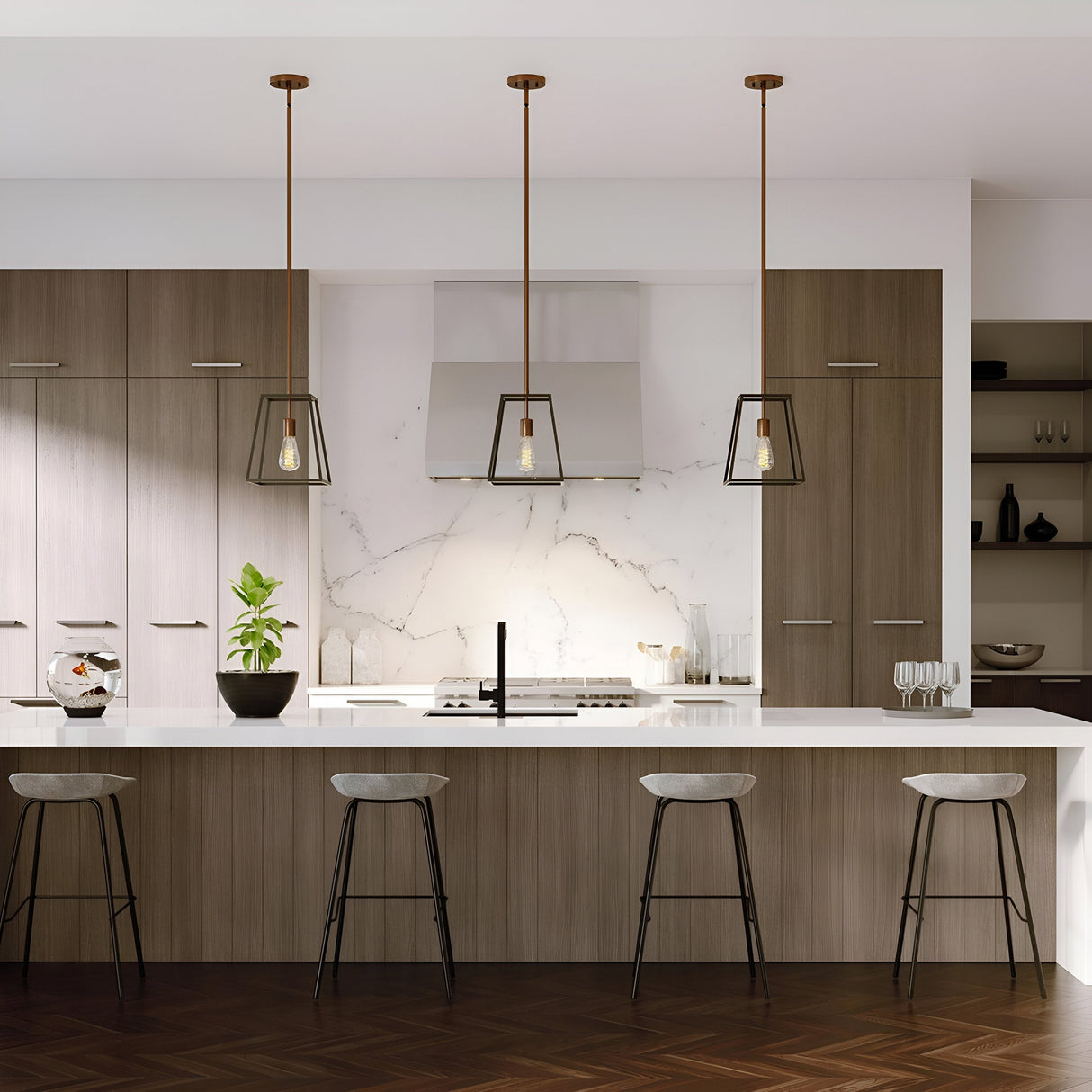 The modern kitchen showcases wooden cabinets and a marble backsplash, complemented by a white island countertop accompanied by four barstools. It features the Fulton 1 Light Pendant in bronze and brass, alongside a small plant. Sleek appliances enhance the minimalist design of the space.