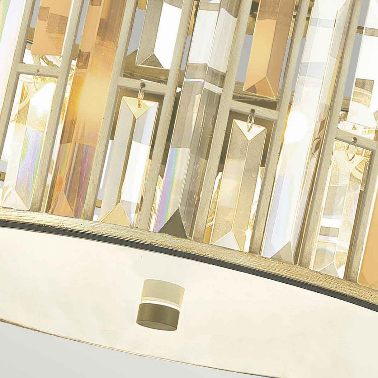 A close-up of the Gemma 3 Light Flush - Gold illuminates the beauty of its vertically arranged crystal prisms, which reflect light to create a shimmering effect. The gold-toned metal frame adds an elegant touch to this exquisite design.